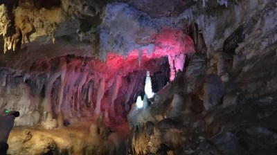 Colorful illuminated cave with stalactites and stalagmites.