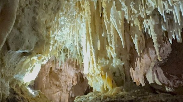 Cave interior with stalactites hanging from the ceiling.