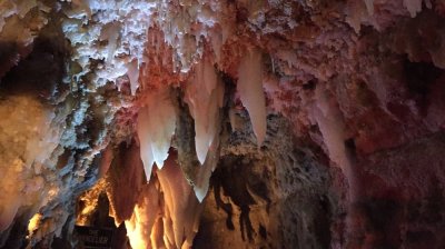Stalagmites and stalactites in a dimly lit cave.