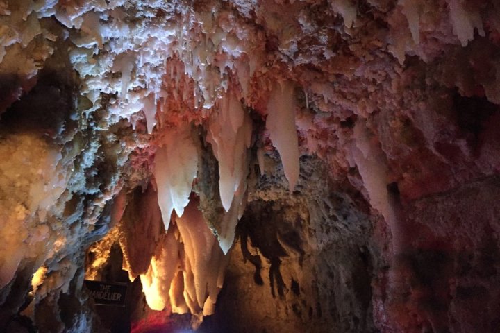 Stalagmites and stalactites in a dimly lit cave.